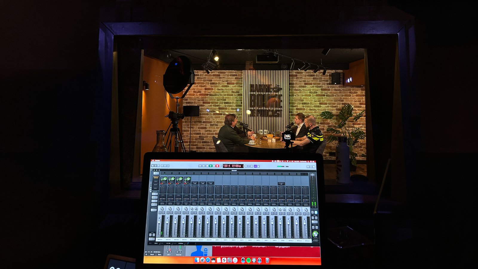 Opname van Bakkie met Bouke in de studio, met het podcastlogo op de achterwand